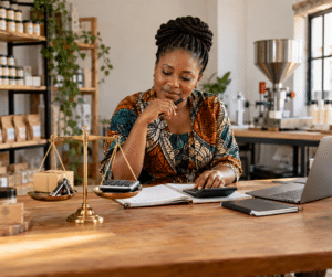 Nigerian business owner reviewing equipment, financial records and profit to estimate the value of her company